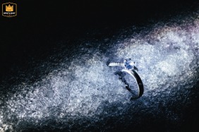 A wedding ring is featured in the foreground, catching the brilliant light and shadow of ice and snow during a winter day in Kaifeng, China.